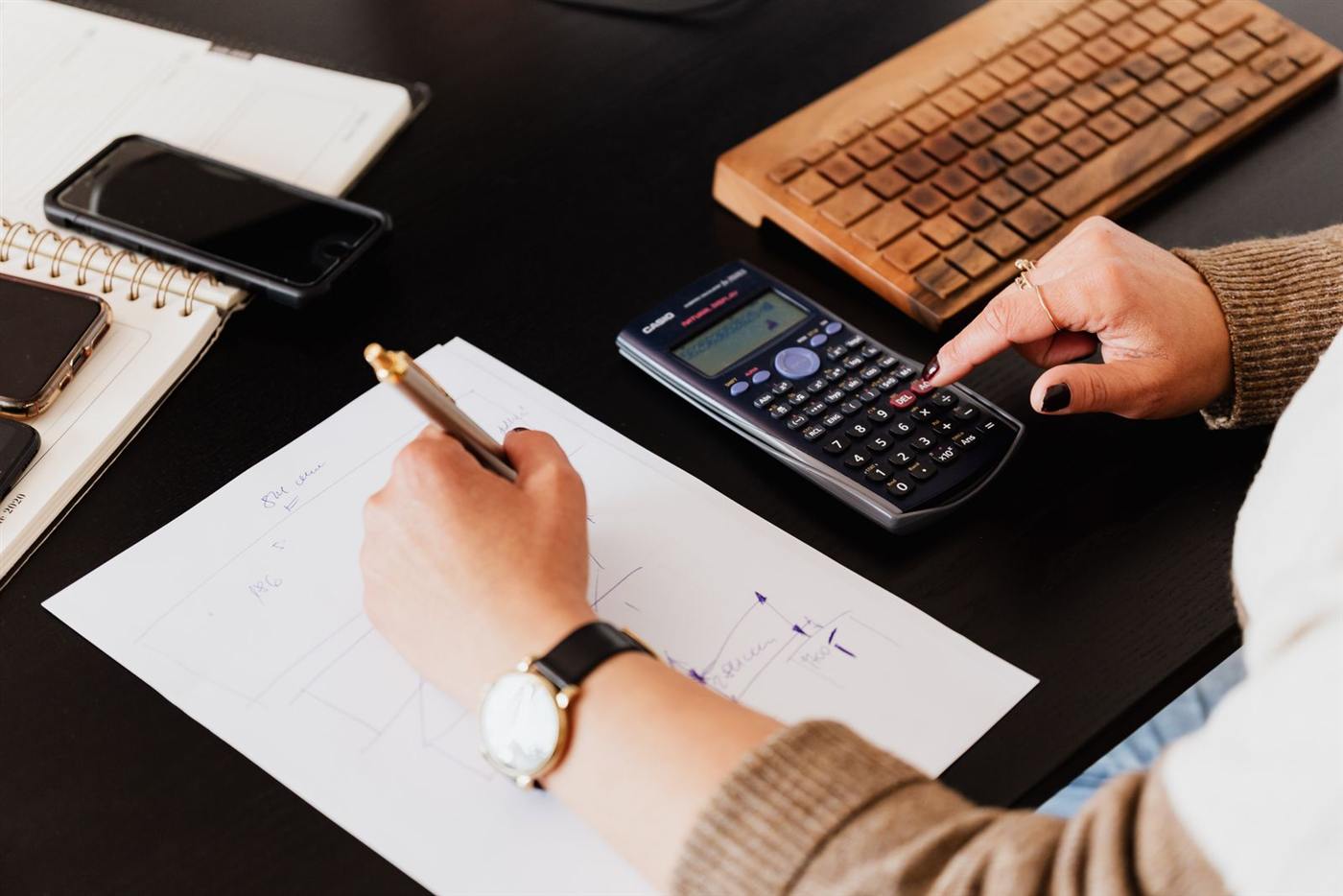 Bookkeeper working with a calculator and notes