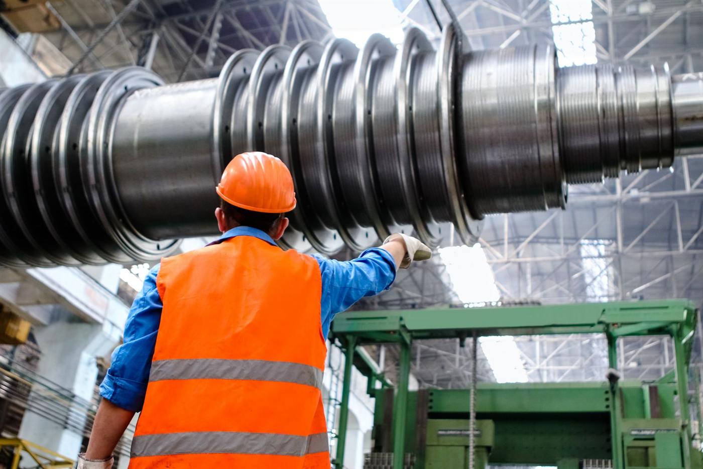 Engineer in safety gear inspecting industrial machinery