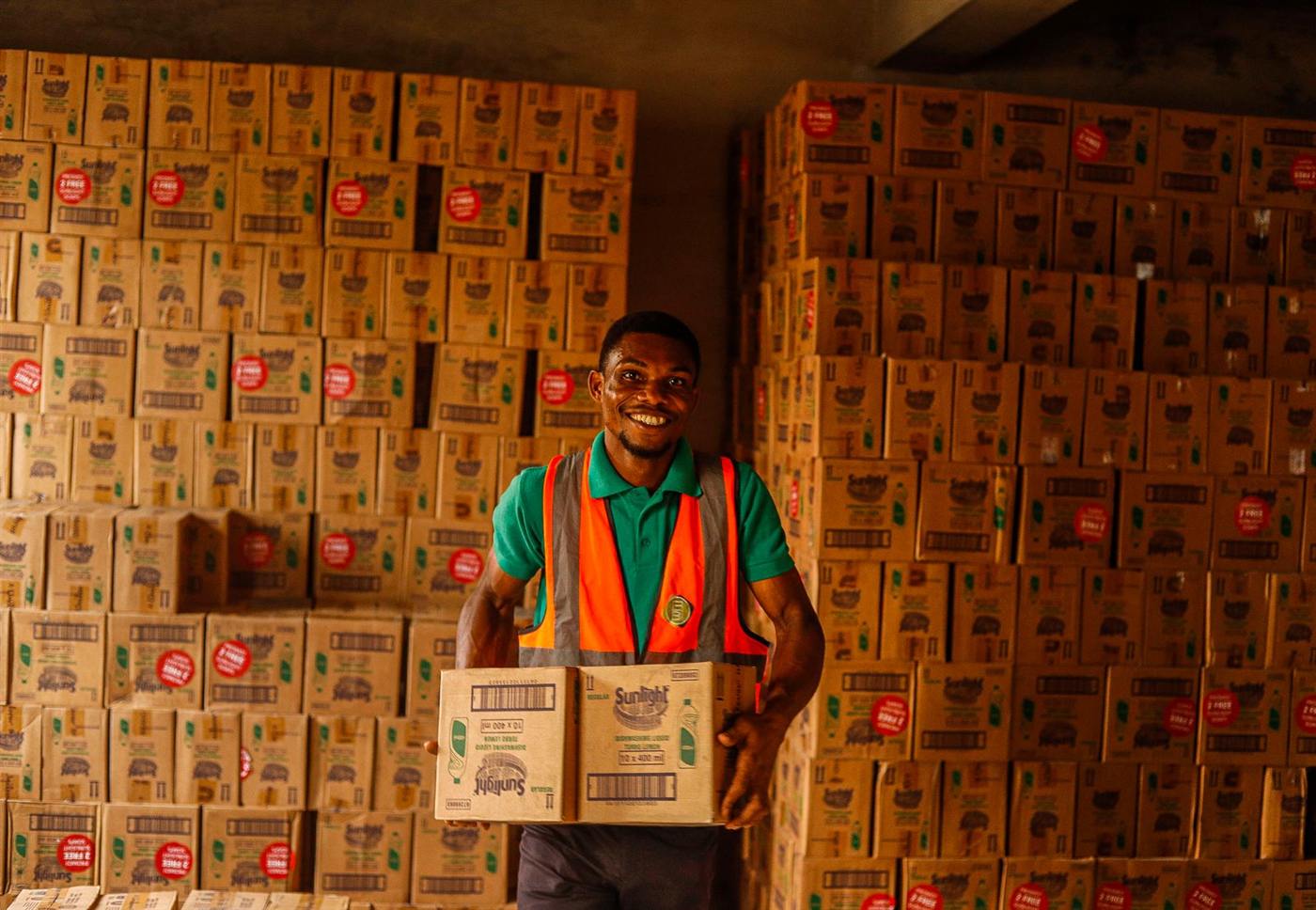 Smiling warehouse worker holding a box